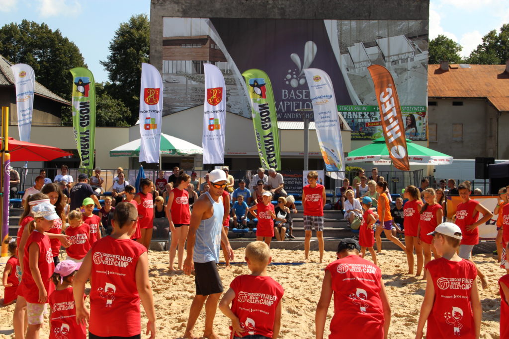 dzieci biorą udział w treningu siatkówki plażowej